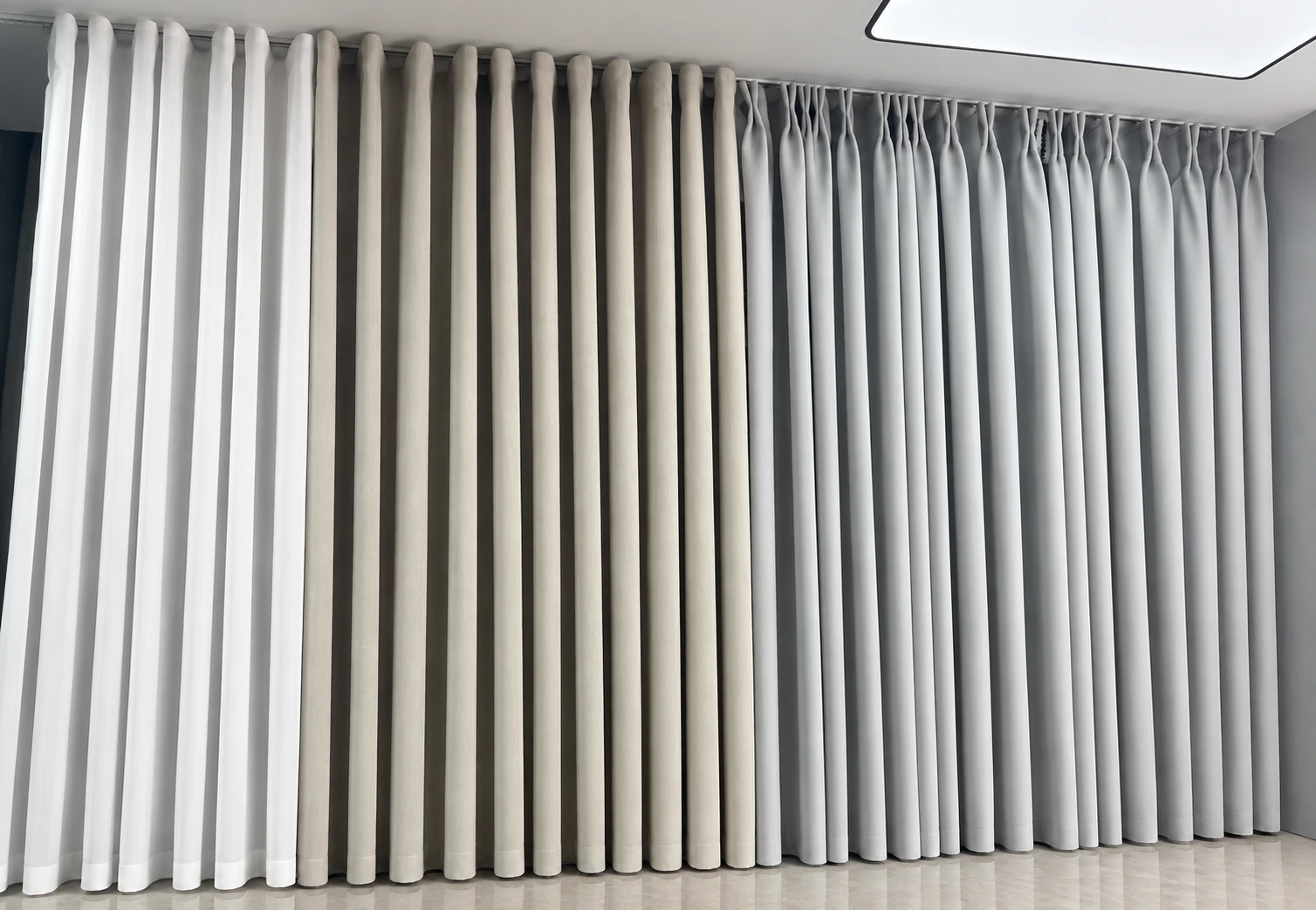 Side-by-side curtain headings: white sheers and beige curtains with rounded ripple folds on the left and centre, and grey curtains with gathered pleat headings on the right.