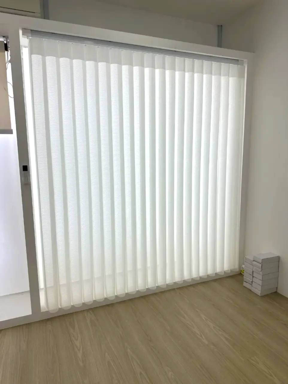 Large glazed opening covered with closely arranged soft translucent white vertical fabric vanes; Dream-style appearance.