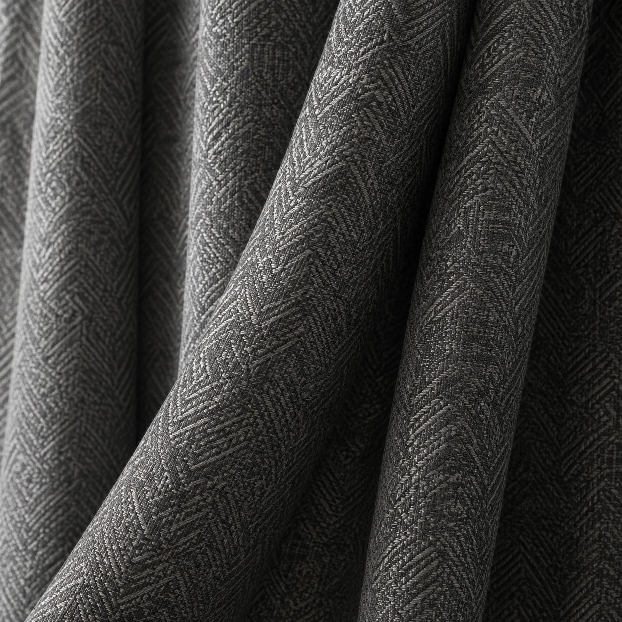 Illustrative charcoal jacquard curtain folds with subtle diagonal woven pattern and fine silver-grey sheen.