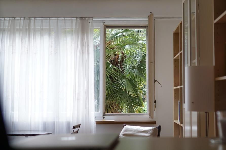 Sunny bathroom window with light curtain – showcases privacy and natural light balance in small-space interior design